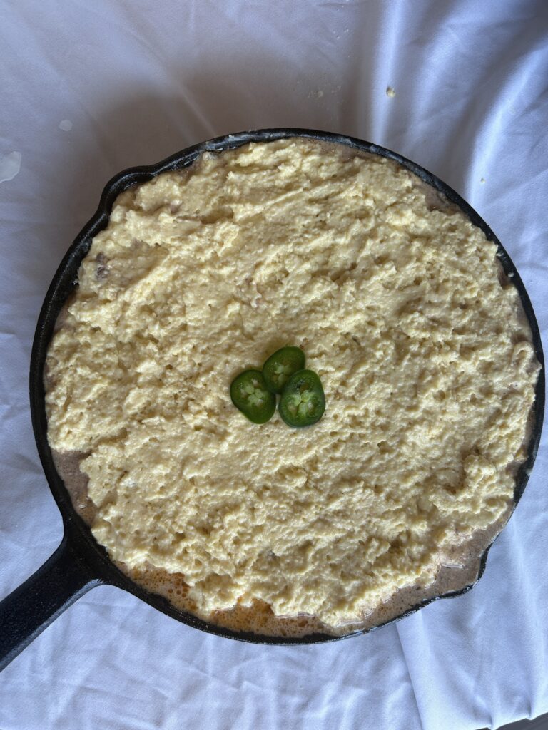 mexican cornbread casserole assembled in cast iron before baking