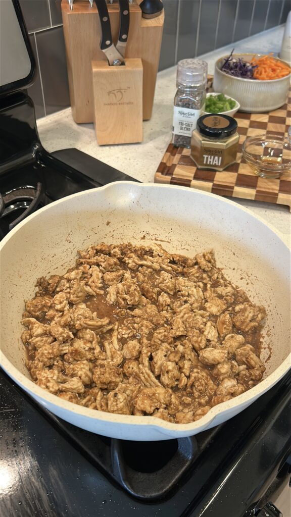 adding Thai seasoning and sauce to ground chicken for lettuce wraps
