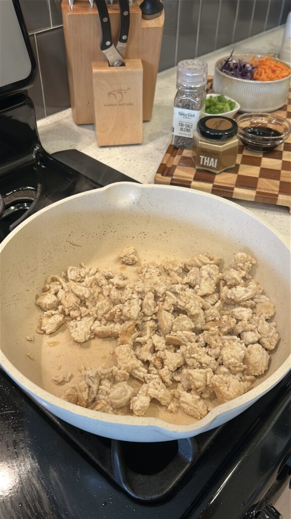 ground chicken cooking in skillet for Thai chicken lettuce wraps