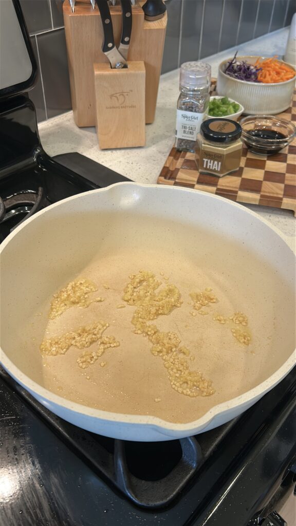 garlic and ginger cooking in skillet for Thai chicken lettuce wraps
