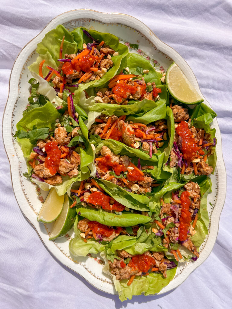 plate of Thai chicken lettuce wraps with ground chicken and toppings