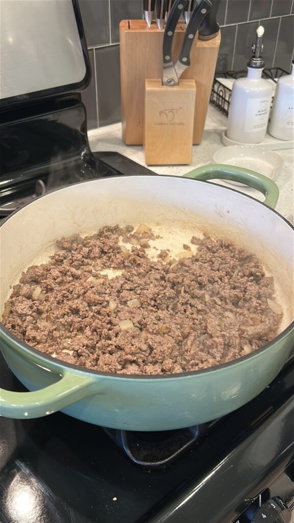Ground beef browning in skillet for cheeseburger bowls