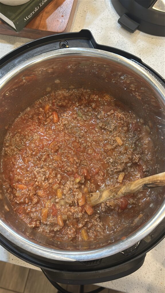 Building Instant Pot Bolognese sauce with tomatoes, broth, and Italian seasoning