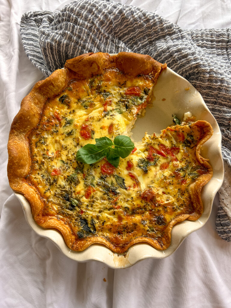 Slice of caprese quiche with mozzarella basil and tomatoes