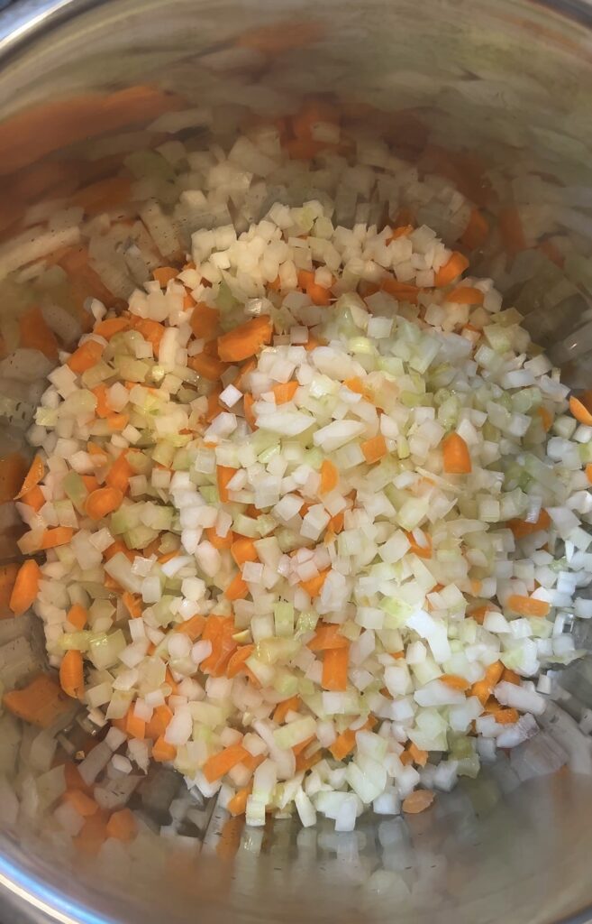 Onion, carrots, celery, and garlic cooking in the Instant Pot for Bolognese sauce