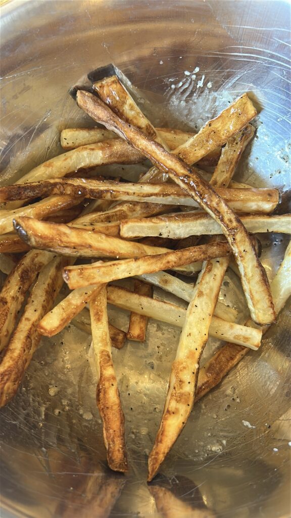 Tossing air fryer fries with garlic butter