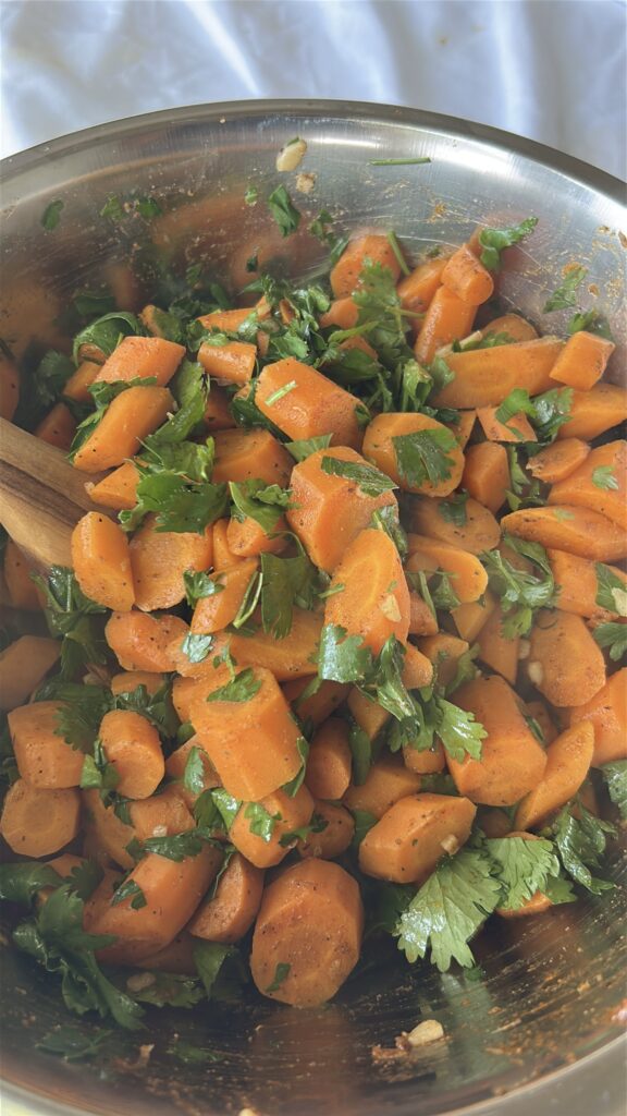 Fresh parsley and cilantro being added to Moroccan carrot salad