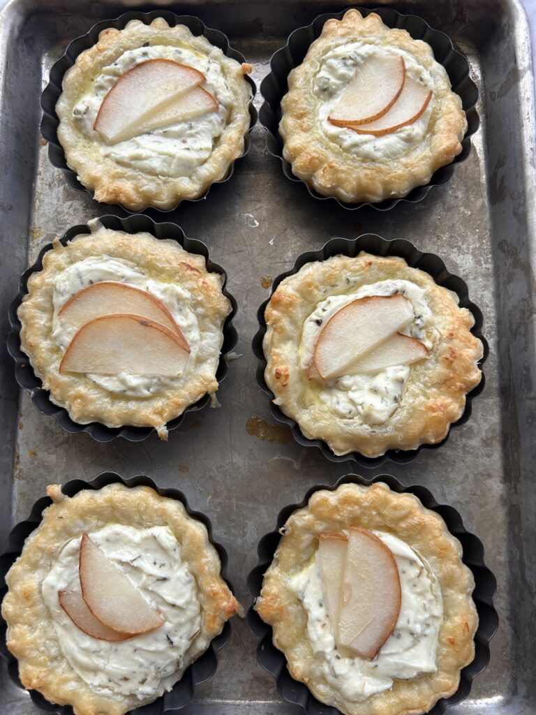 Freshly baked lavender goat cheese tartlets with golden puff pastry and pears