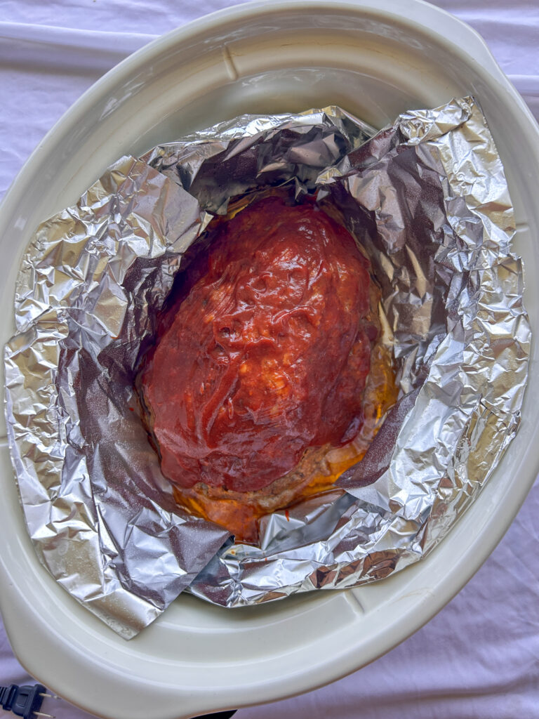 Crockpot meatloaf brushed with a second layer of sweet and tangy glaze