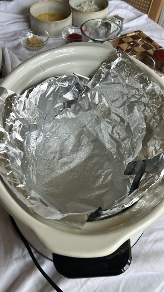 Foil sling prepared inside a slow cooker for making crockpot meatloaf