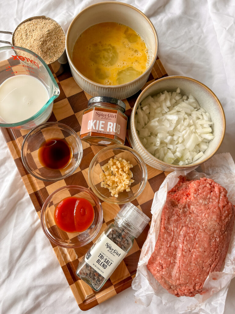 Ingredients for crockpot meatloaf including ground beef, breadcrumbs, onion, garlic, eggs, milk, and seasonings