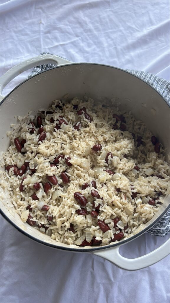 Fluffing cooked Jamaican rice and peas with a fork before serving