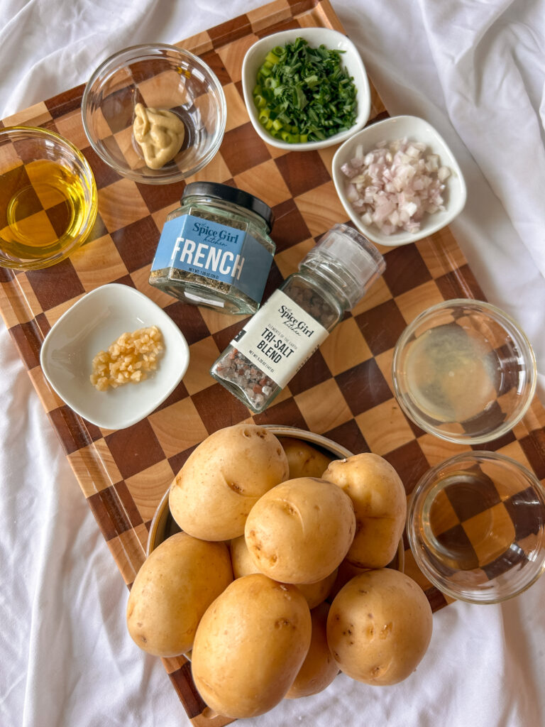 Ingredients for French potato salad including potatoes, Dijon mustard, olive oil, champagne vinegar, garlic, shallots, herbs, and Herbes de Provence