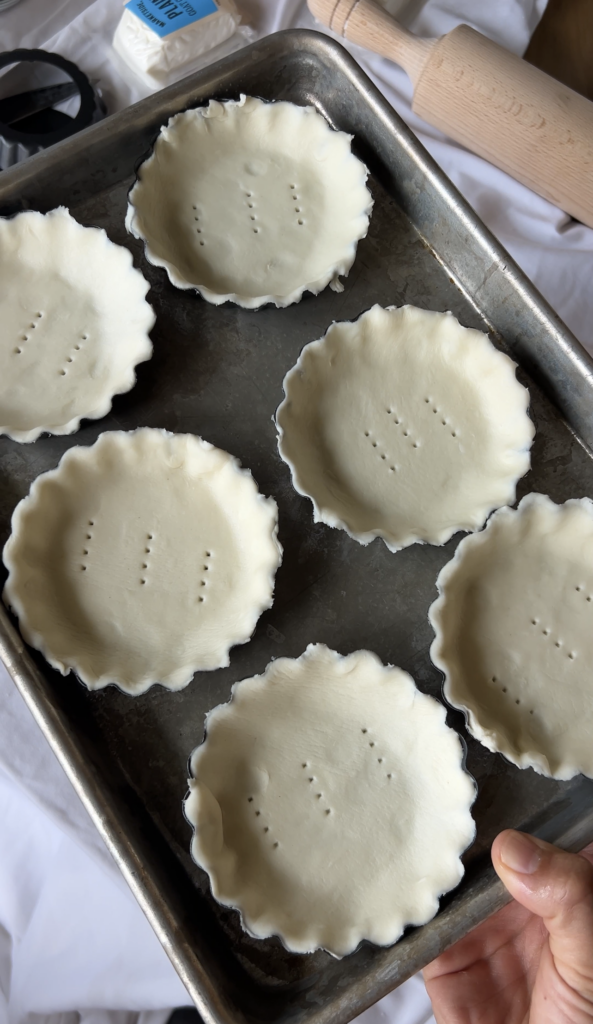 Puff pastry pressed into individual tart pans before baking