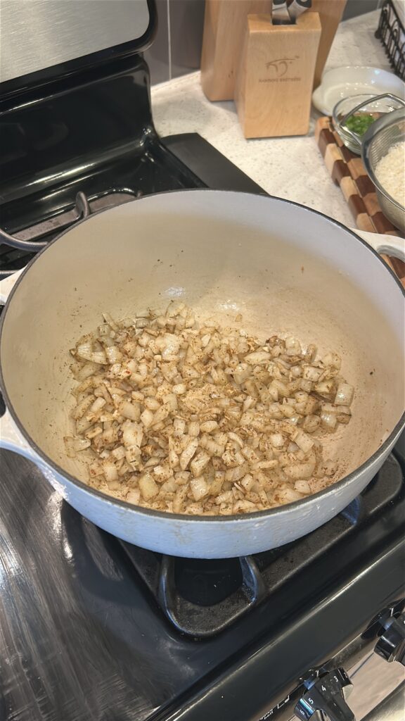Onion and garlic sautéing in a pot for Jamaican rice and peas