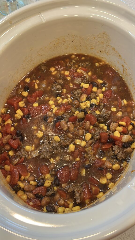 Slow cooker filled with taco soup ingredients before cooking