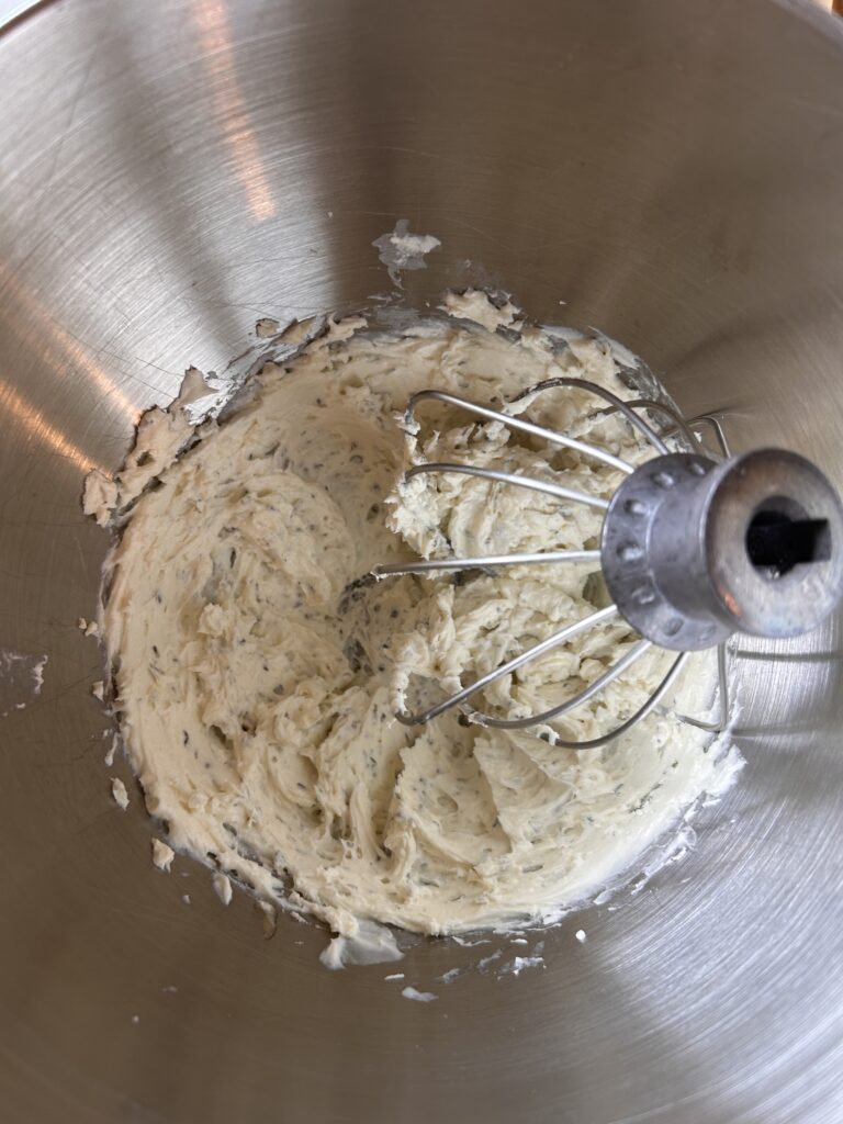Whipped goat cheese filling with honey and French seasoning in a mixing bowl