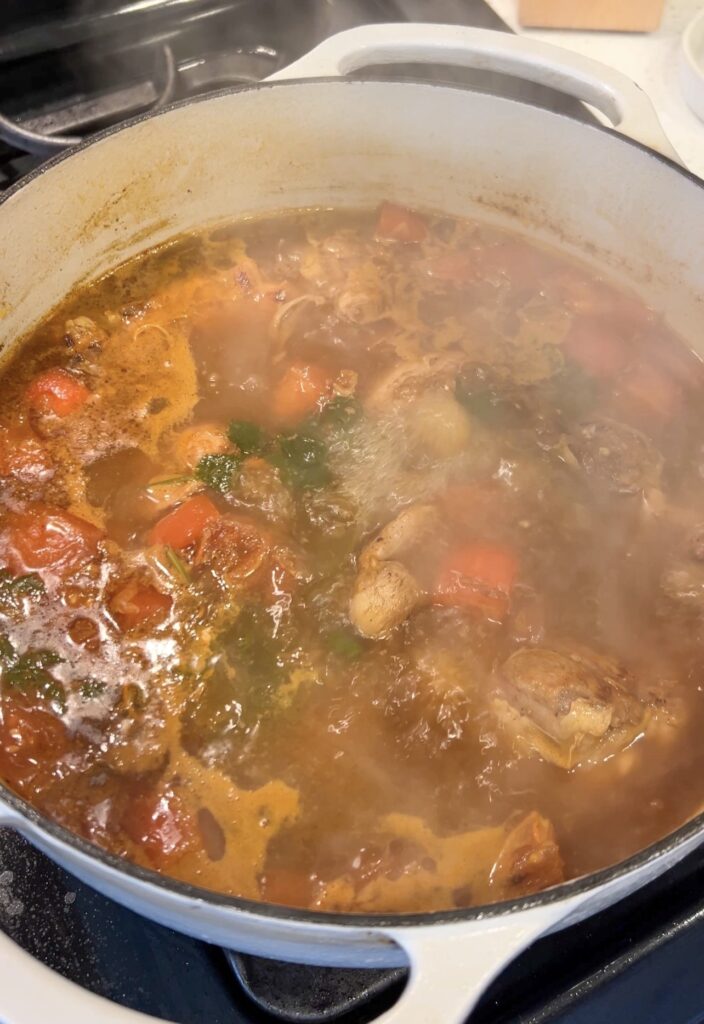 Returning the browned chicken to the Moroccan couscous broth before simmering