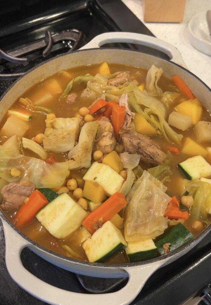 Adding chickpeas and zucchini to Moroccan couscous during the final simmer