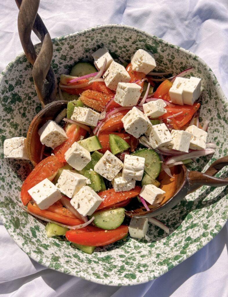Block feta added to authentic Traditional Greek Salad before serving