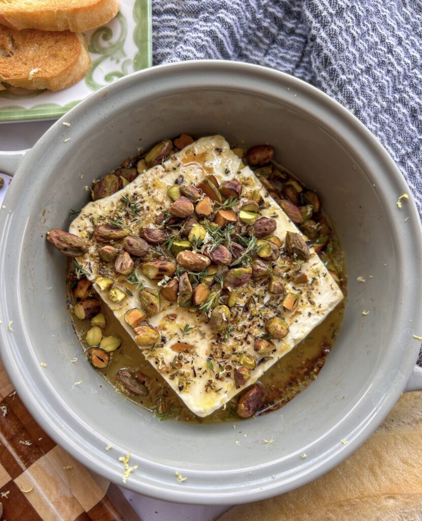 Drizzling warm honey and toasted pistachios over baked feta.