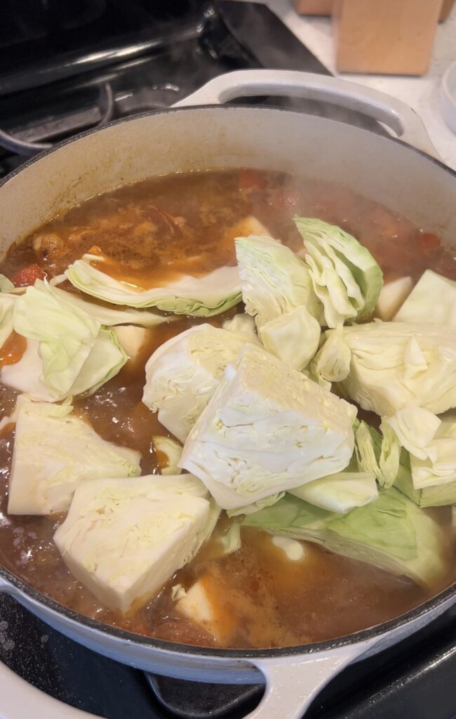 Adding carrots, turnips, and cabbage to the Moroccan couscous broth