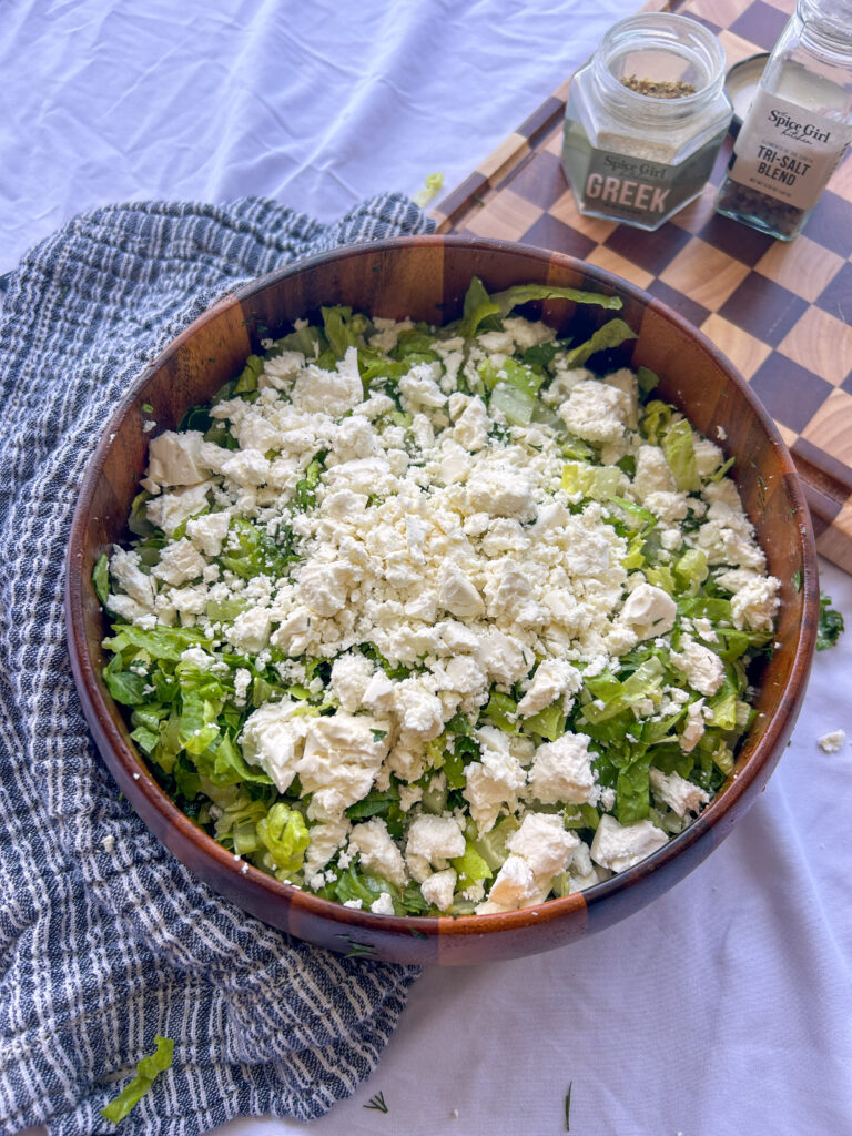 Crumbled feta cheese added to finished maroulosalata before serving