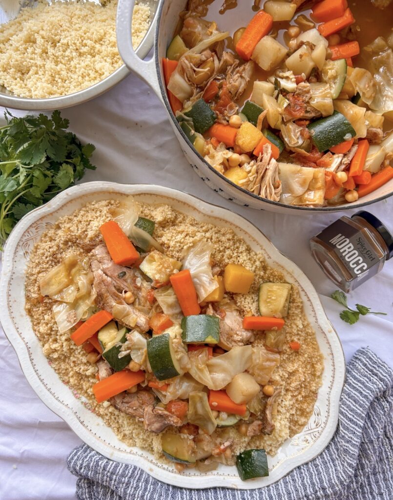 Assembling Moroccan couscous with chicken, vegetables, and broth on a serving platter