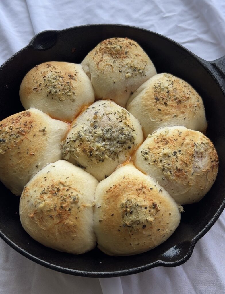 Freshly baked pizza bombs with golden brown tops and melted cheese baked in a cast iron skillet.