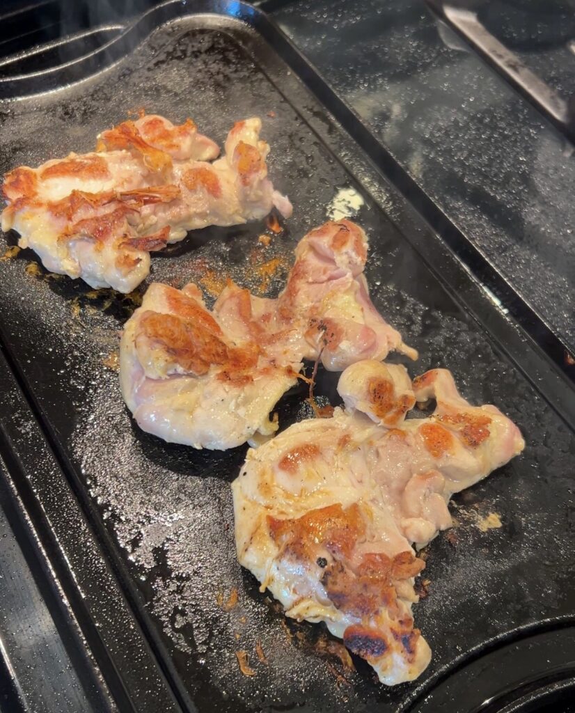 Browning chicken thighs for Moroccan couscous before simmering in the broth