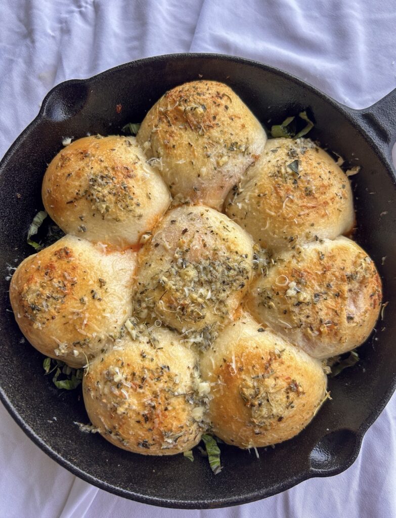 Freshly baked pizza bombs brushed with more Italian garlic butter and sprinkled with Parmesan.