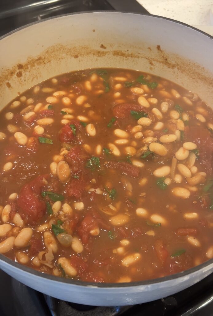 Fresh parsley, cilantro, and lemon juice being added to finish Moroccan white bean stew