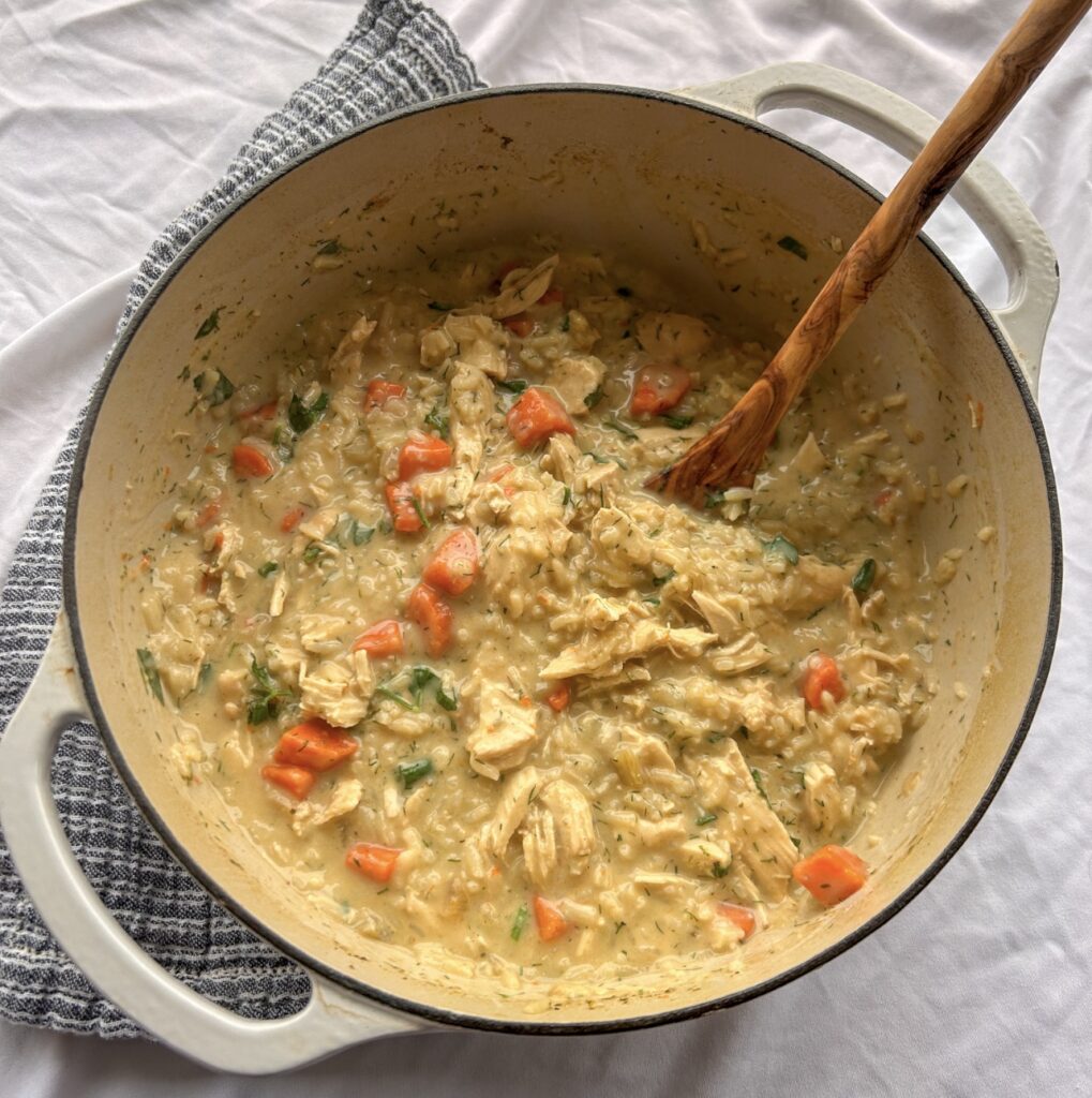 Finished Greek lemon chicken soup with fresh dill, parsley, and cracked black pepper