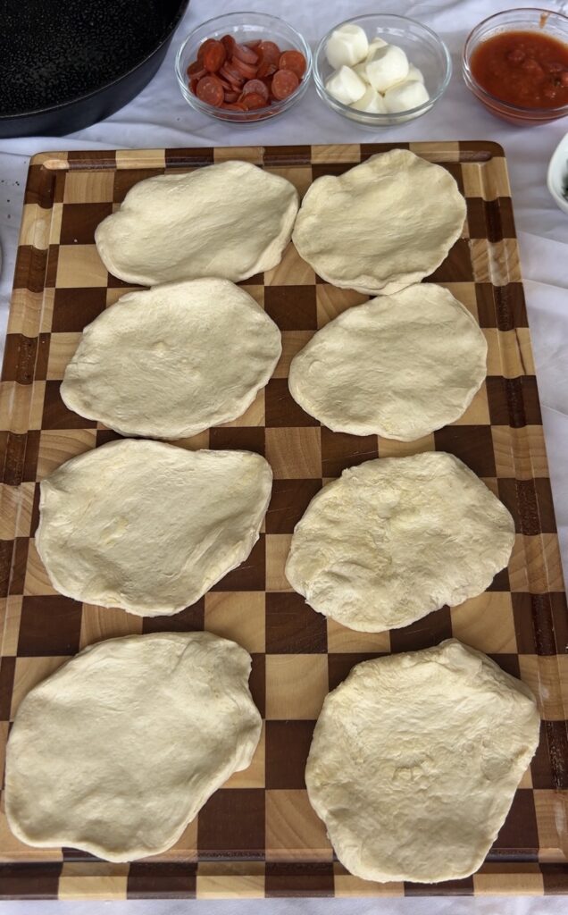 Refrigerated biscuit dough flattened into rounds for making homemade pizza bombs.