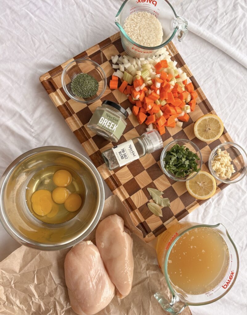 Ingredients for Greek lemon chicken soup including chicken, rice, vegetables, eggs, lemon, herbs, and Greek seasoning