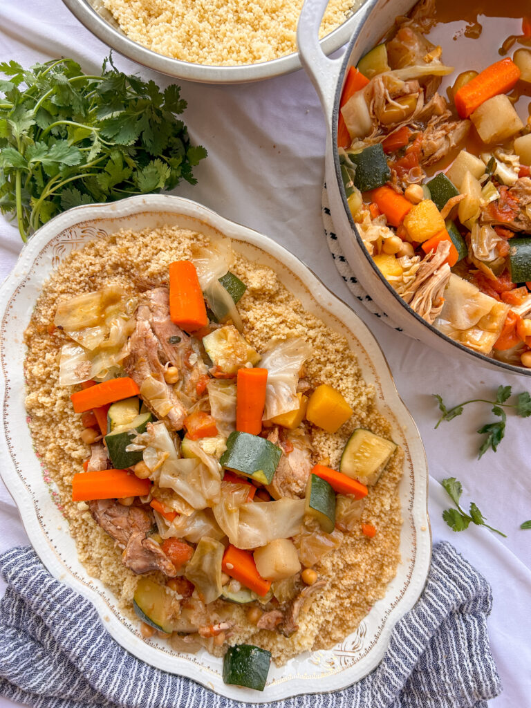 Moroccan couscous with chicken, seven vegetables, chickpeas, and fluffy couscous served on a platter