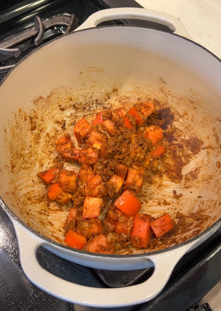 Building the flavorful broth with tomatoes, onions, herbs, and Moroccan seasoning