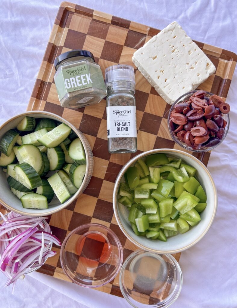 Chopped cucumber, green bell pepper, red onion, and Kalamata olives prepared for Traditional Greek Salad