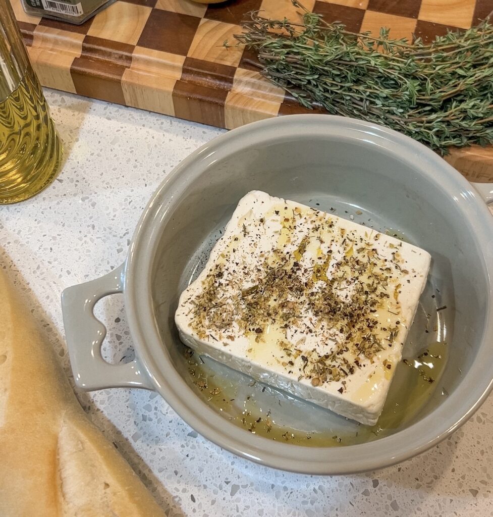 Drizzling olive oil and sprinkling Greek seasoning over feta before baking.