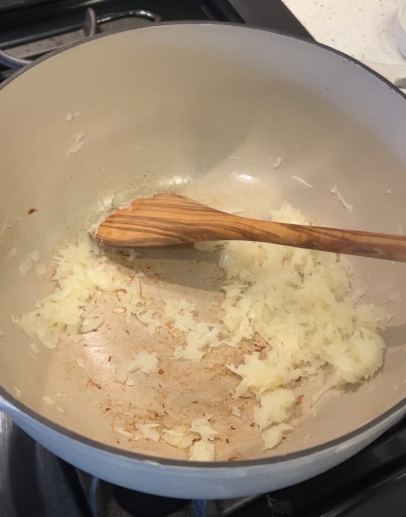 Grated onion sautéing in olive oil for Moroccan white bean stew