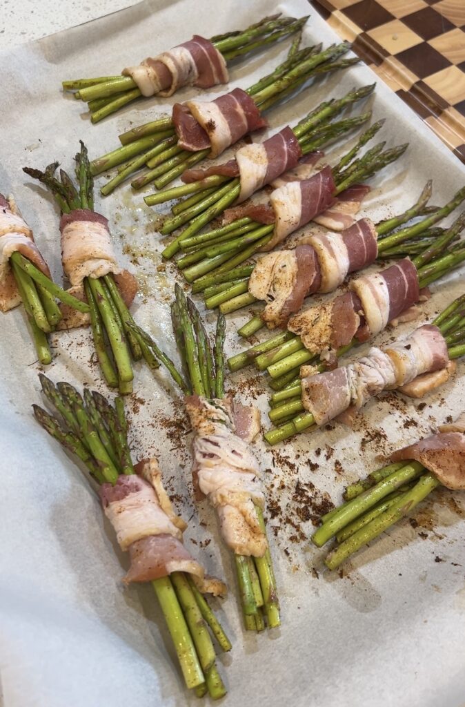 Seasoned asparagus bundles wrapped with thin-cut bacon before baking