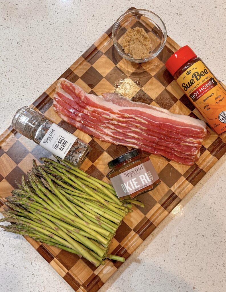 Ingredients for bacon wrapped asparagus with bacon, fresh asparagus, Okie Rub, brown sugar, hot honey, olive oil and salt