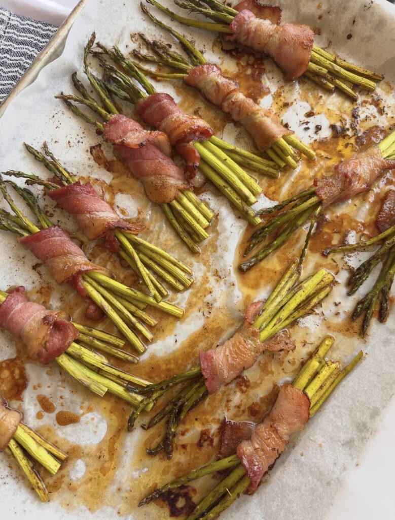 Bacon wrapped asparagus bundles baked until the asparagus is tender and the bacon is crisp and caramelized