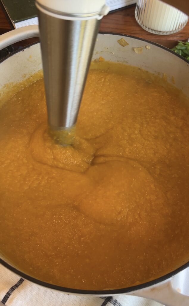 Blending butternut squash lentil soup with an immersion blender