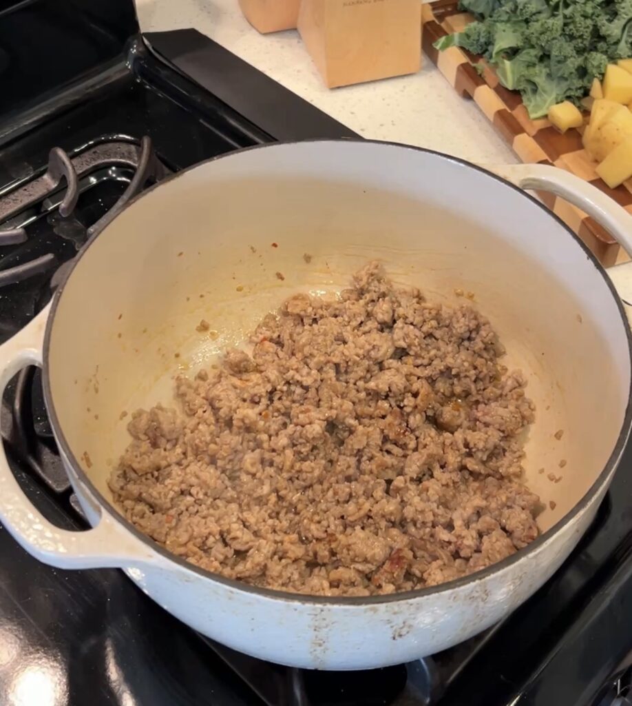 Italian sausage browning in a Dutch oven for Zuppa Toscana
