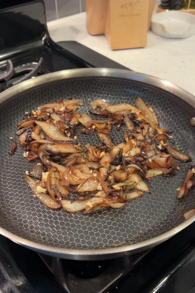 Yellow onions cooked until deeply golden and caramelized in a skillet