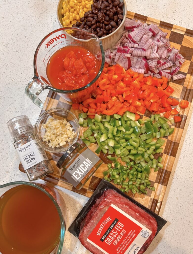 Ingredients for easy taco soup with ground beef, black beans, corn, tomatoes, peppers, beef broth, and seasoning