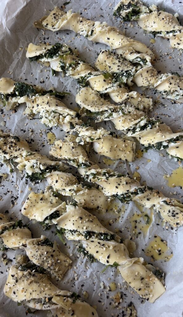 Unbaked puff pastry twists topped with egg wash and everything bagel seasoning