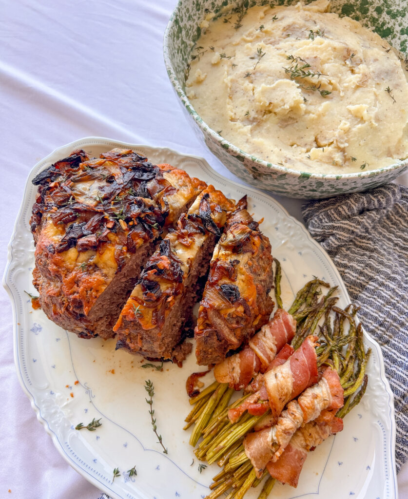 French onion meatloaf topped with caramelized onions and melted Gruyère cheese