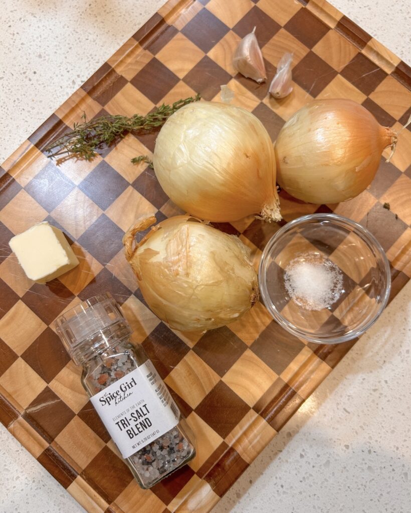 Ingredients for caramelized onions including yellow onions, butter, garlic, and fresh thyme
